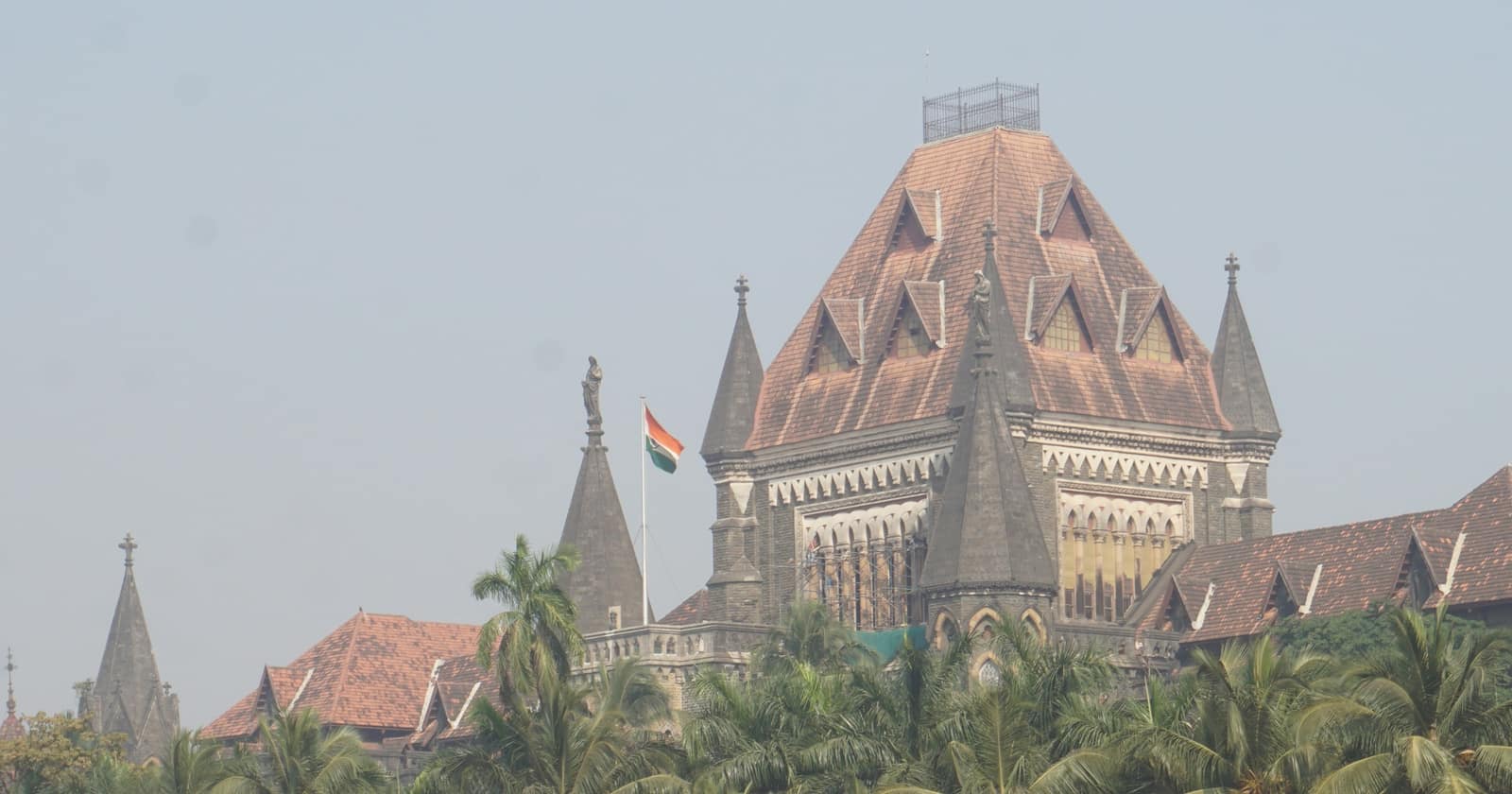 The gabled roof and spires of the Bombay High Court above palm trees, the tricolour flying beside it